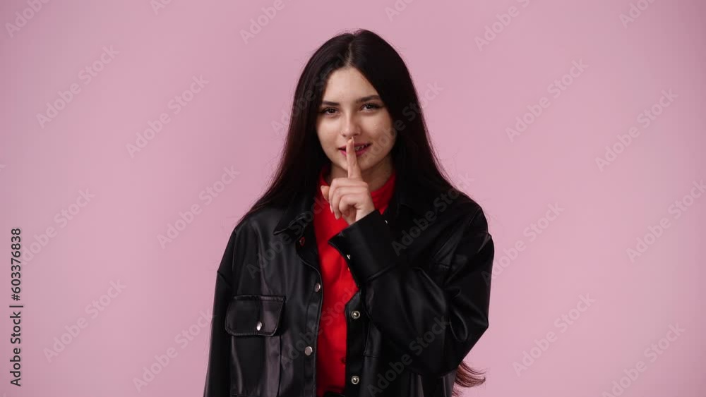 4k video of one girl looks around and showing silence sign over pink background. 4k video of one girl looks around and showing silence sign over pink background.
