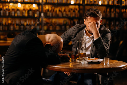 drunken men sleeping on a table in a pub after work. friends, colleagues, drink alcohol