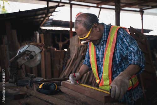 An elderly carpenter works the wood with meticulous care.