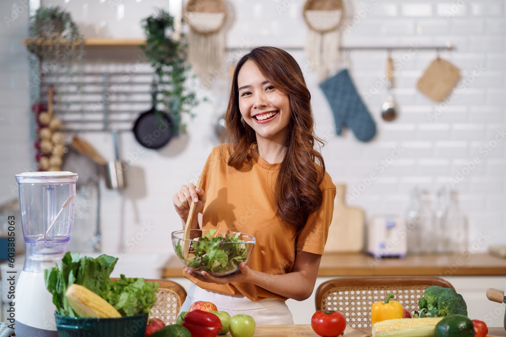 Young Asian woman is preparing a fresh healthy vegan salad with many vegetables in the kitchen, Dieting Concept. Healthy food Lifestyle. Cooking At Home. Young Asian woman is preparing a fresh healthy vegan salad with many vegetables in the kitchen, Dieting Concept. Healthy food Lifestyle. Cooking At Home.