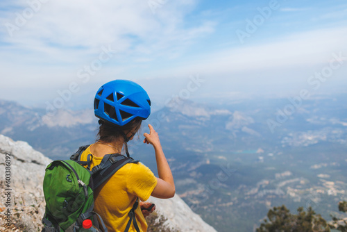 climber goes along the rocky ridge. girl climbing in the mountains. the concept of adventure and hiking in the mountains.