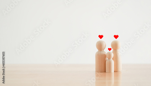 Happy family with one child and heart emotion on wooden background. Wood doll character. Togetherness relationship and lifestyle concept.