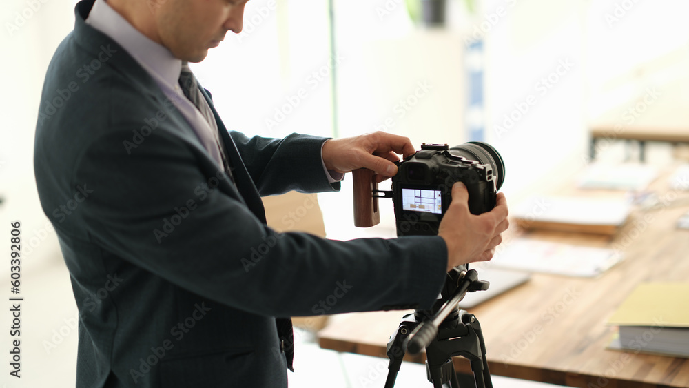 Man in suit business blogger adjusting camera in conference room. Business education online concept