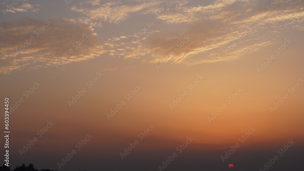 The beautiful sunset view with the buildings' silhouette and orange color sky as background in the city The beautiful sunset view with the buildings' silhouette and orange color sky as background in the city