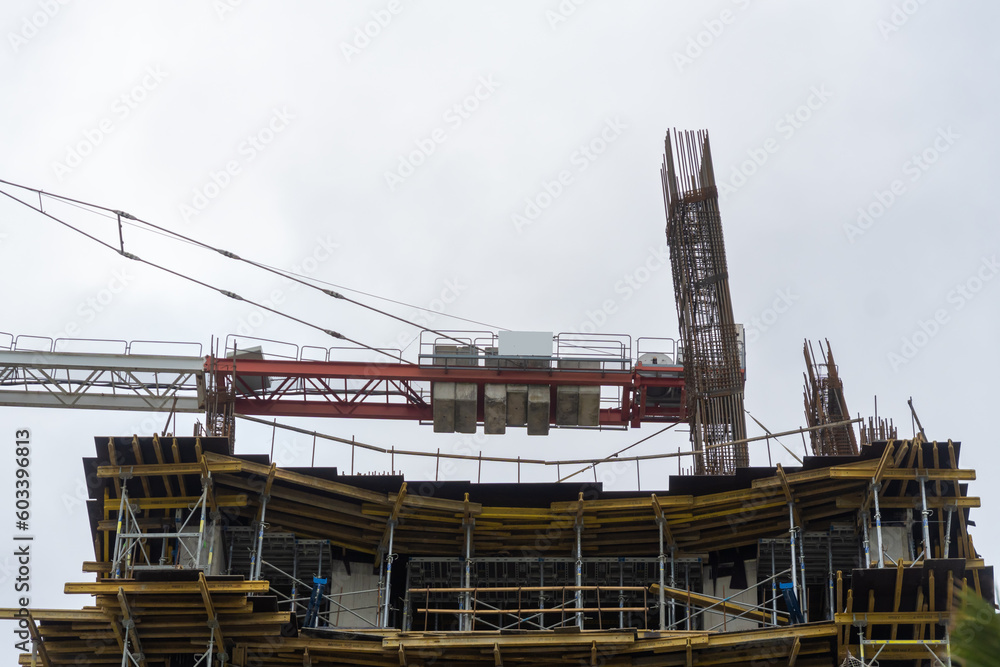 Close-up of a construction site, a crane, piles against a gray sky. Construction concept