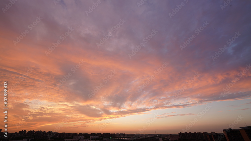 The beautiful sunset view with the buildings' silhouette and orange color sky as background in the city