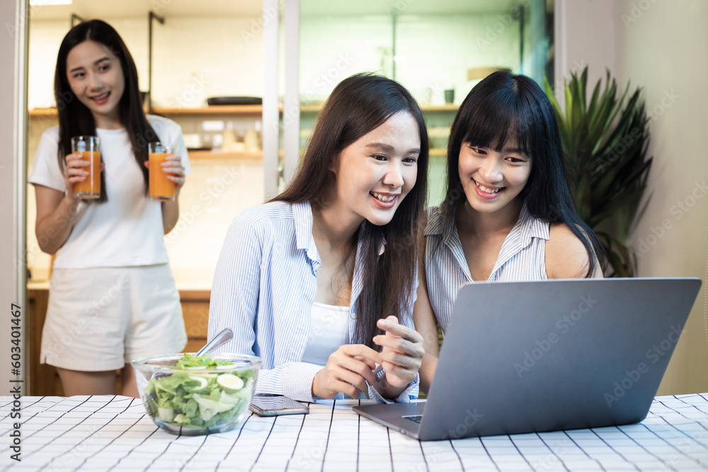 Asian lgbtq and teenage woman looking at laptop computer at home office, happy family work together, Gay pride festival - LGBTQ community concept Asian lgbtq and teenage woman looking at laptop computer at home office, happy family work together, Gay pride festival - LGBTQ community concept