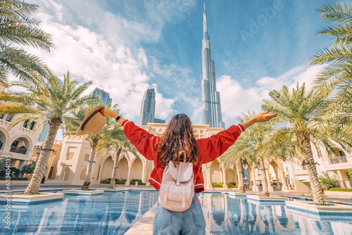 From behind, you can see the traveler girl arms spread wide as she take in the incredible view of the and the Dubai skyline. photo