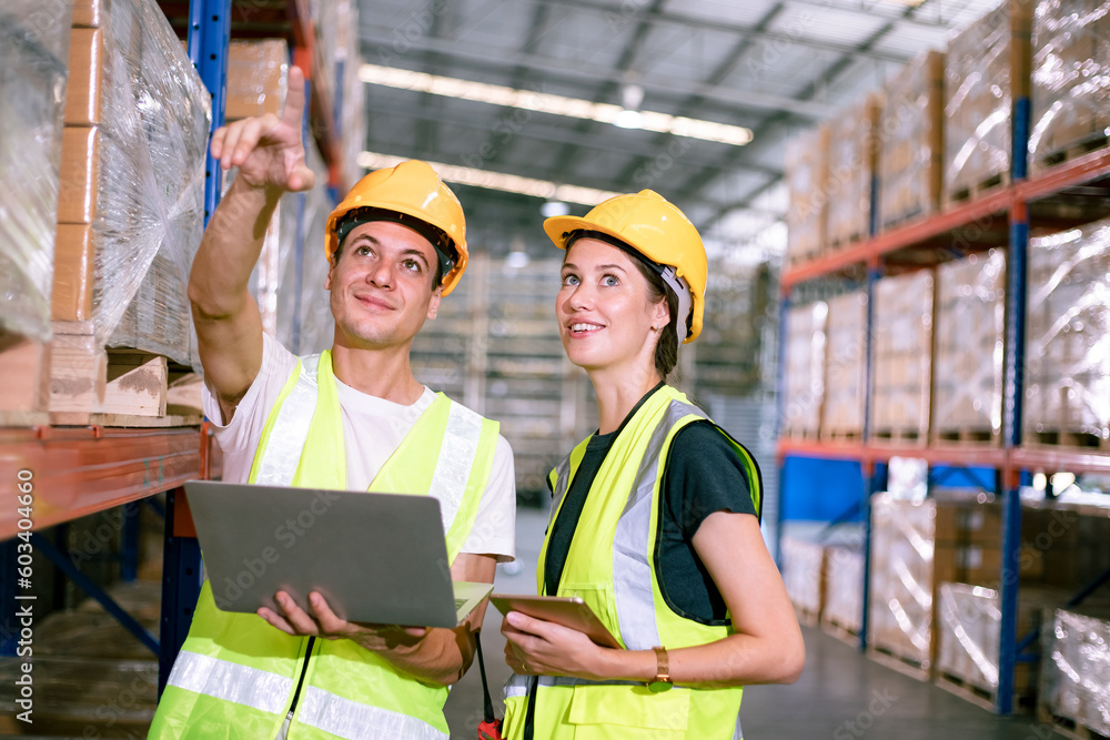 Warehouse workers talking through large storage department discussing about distribution and logistics. Warehouse interior with palette of goods and shelves. Warehouse workers talking through large storage department discussing about distribution and logistics. Warehouse interior with palette of goods and shelves.