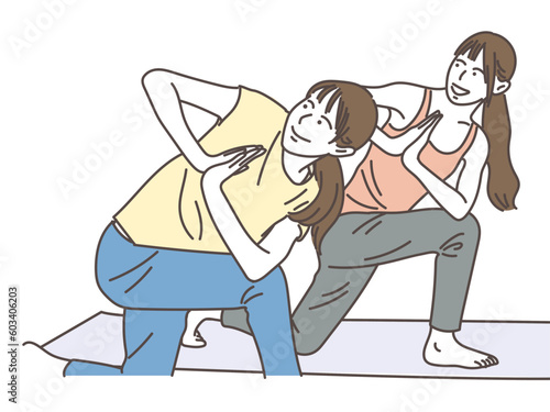 ヨガのひねりのポーズをする若い女性達
