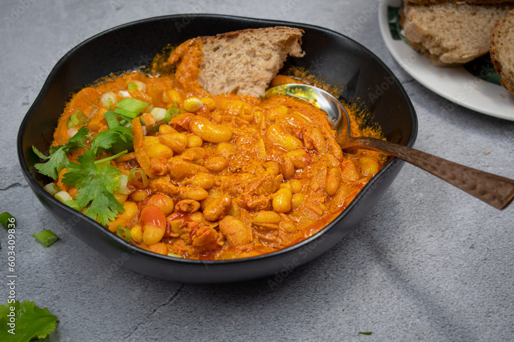 Vegan bean curry bowl, served with bread slices Vegan bean curry bowl, served with bread slices