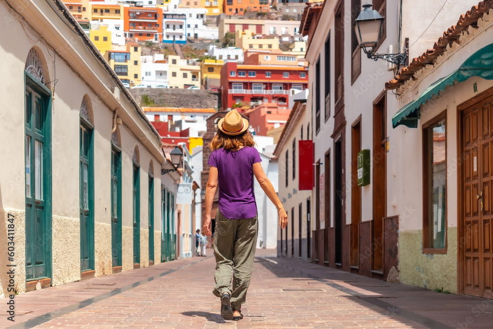 Woman on vacation walking through the city of San Sebastian de la Gomera next to the Iglesia De La Asuncion, Canary Islands