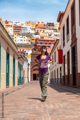 Vacation concept, woman enjoying in the city of San Sebastian de la Gomera next to the Iglesia De La Asuncion, Canary Islands