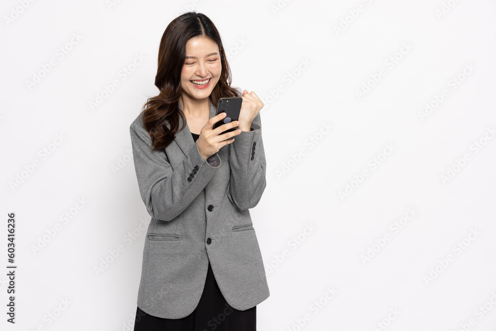 Happy Asian businesswoman typing or using mobile phone isolated on white background Happy Asian businesswoman typing or using mobile phone isolated on white background