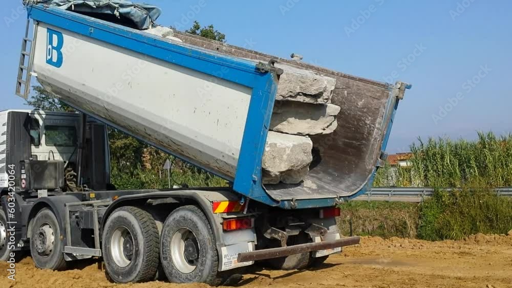 Camion Bilico scarica scogli di marmo in cantiere di edilizia idraulica. Messa in sicurezza idraulica Camion Bilico scarica scogli di marmo in cantiere di edilizia idraulica. Messa in sicurezza idraulica