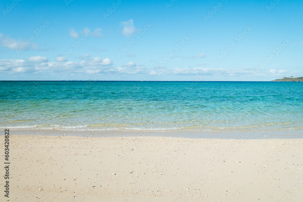 Empty white sandy beach with blue sky and white clouds