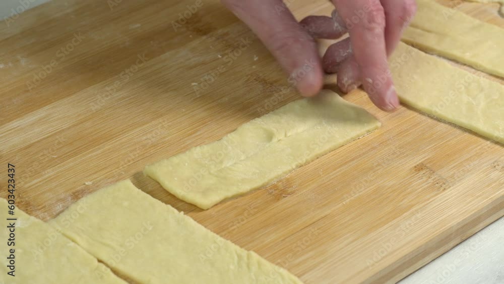 The chef cuts by knife slices of dough and rolls them into biscuits before deep-frying them. Cooking pasta at home. Cooking and dessert The chef cuts by knife slices of dough and rolls them into biscuits before deep-frying them. Cooking pasta at home. Cooking and dessert