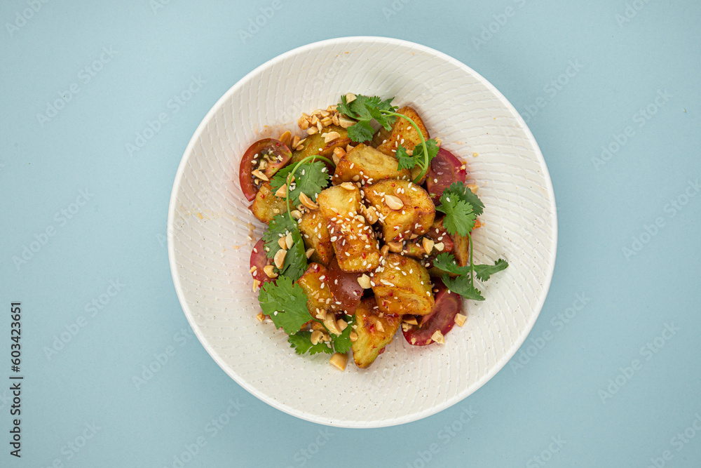 Portion of gourmet crispy fried eggplant salad on blue background