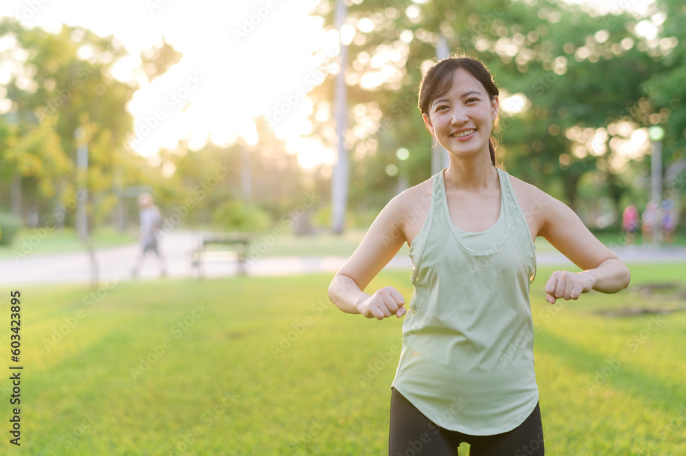 Female jogger. Fit young Asian woman with green sportswear stretching muscle in park before running and enjoying a healthy outdoor. Fitness runner girl in public park. Wellness being concept Female jogger. Fit young Asian woman with green sportswear stretching muscle in park before running and enjoying a healthy outdoor. Fitness runner girl in public park. Wellness being concept