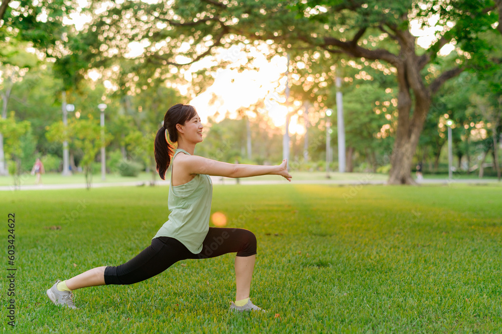 Female jogger. Fit young Asian woman with green sportswear stretching muscle in park before running and enjoying a healthy outdoor. Fitness runner girl in public park. Wellness being concept Female jogger. Fit young Asian woman with green sportswear stretching muscle in park before running and enjoying a healthy outdoor. Fitness runner girl in public park. Wellness being concept