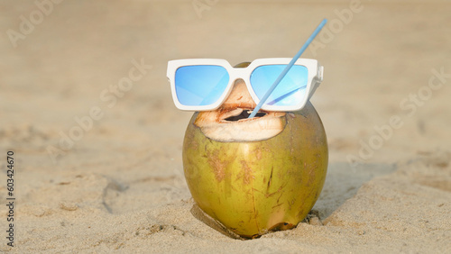 coconut with sunshine glass and straw in its mouth