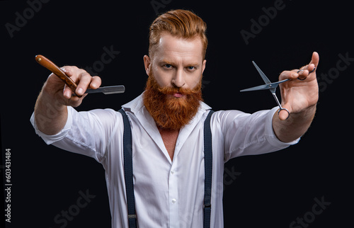 brutal barbershop man in studio. barbershop man with scissors and retro razor blade.