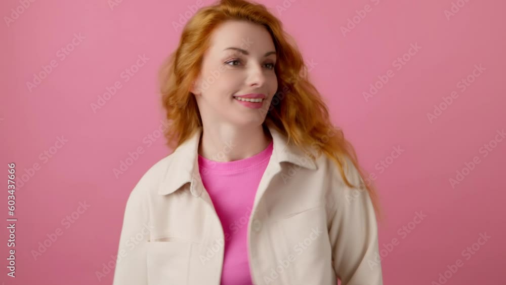 Excited redhead woman dancing moving head and waving her curly hair, having fun , enjoying life, entertainment. Smiling happy emotional female lady dance. Indoor studio isolated on pink background. Excited redhead woman dancing moving head and waving her curly hair, having fun , enjoying life, entertainment. Smiling happy emotional female lady dance. Indoor studio isolated on pink background.