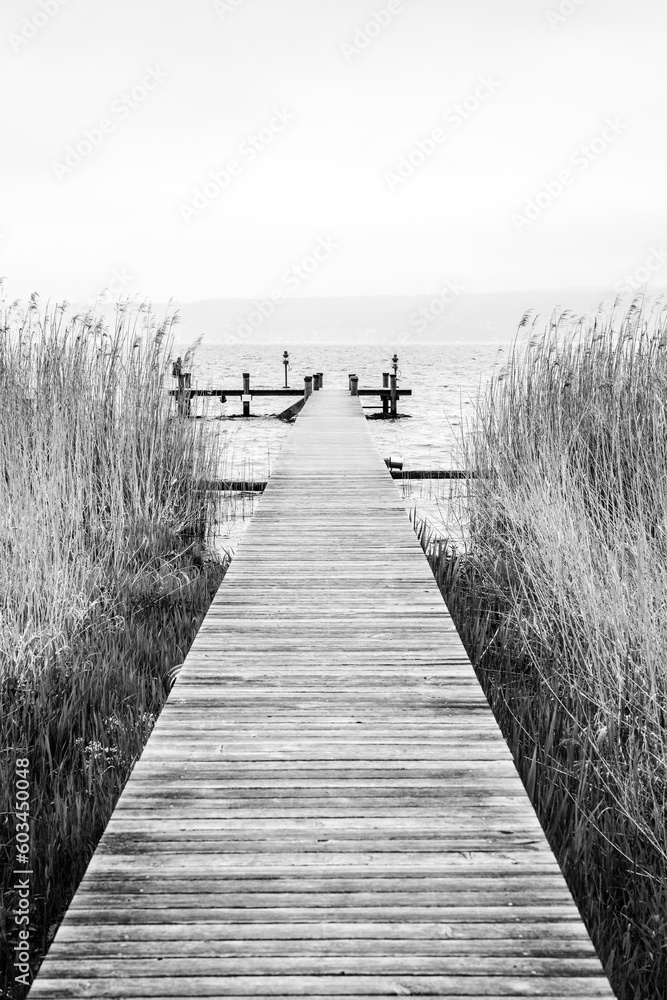 Obraz premium Serene wooden landing stage on a cloudy day at the Ammersee Lake in Bavaria, southern Germany