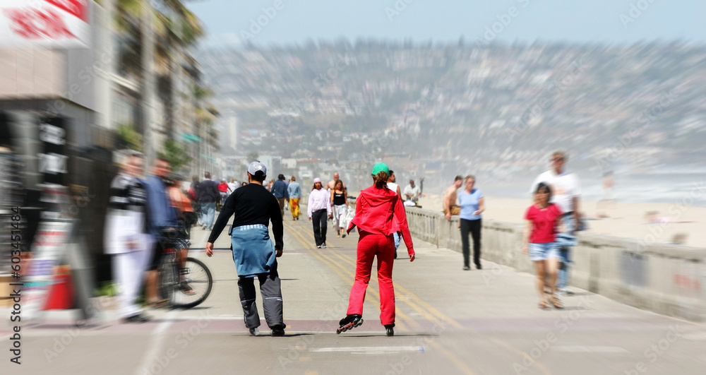 Couple rollerblading along the beach with motion blur
