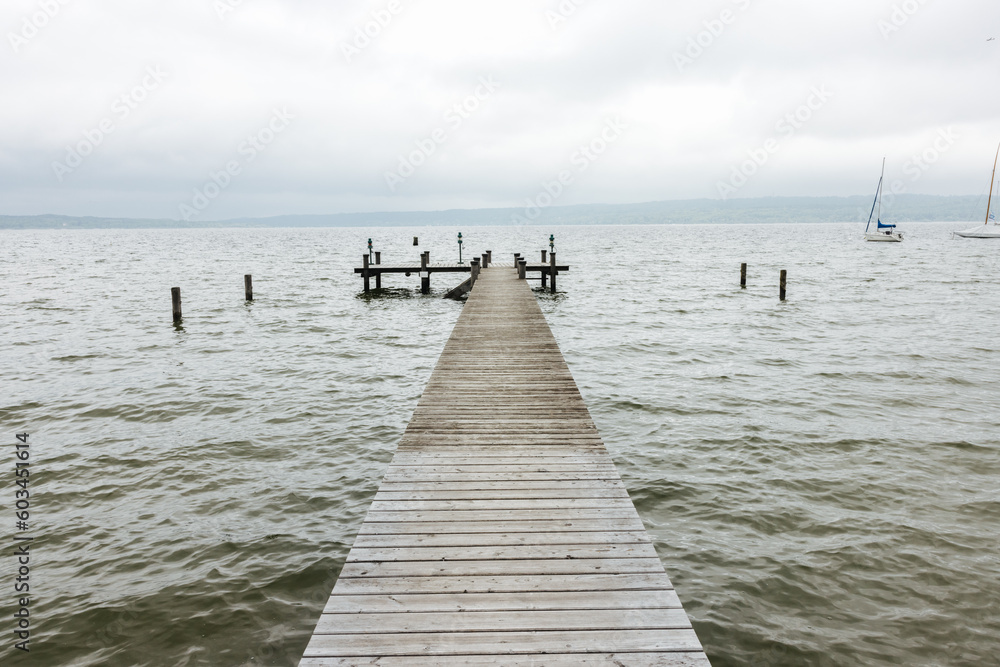 Serene wooden landing stage on a cloudy day at the Ammersee Lake in Bavaria, southern Germany