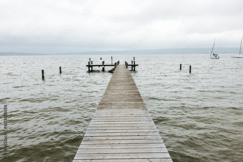 Obraz premium Serene wooden landing stage on a cloudy day at the Ammersee Lake in Bavaria, southern Germany