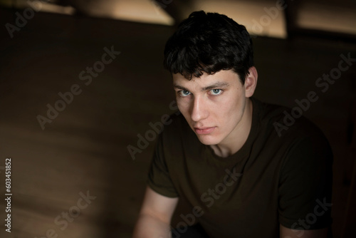 Portrait of a handsome, serious young man of 18 years old, he is resting and thinking about the choice of profession. A serious, slightly sad boy with dark hair and beautiful eyes