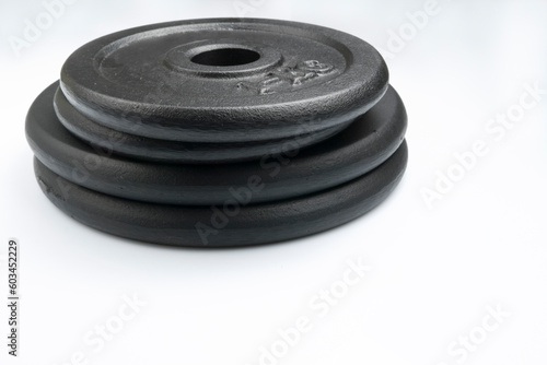 Stack of black weights on a white background. Horizontal shot.