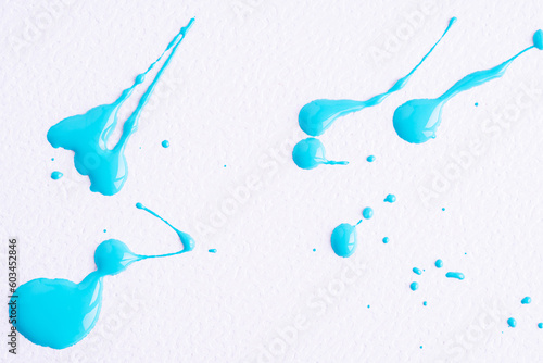 Watercolor blue drop splash. Splattered of blue ink drops on white paper background. Sample of cosmetics. The puddle of an oil paint spill