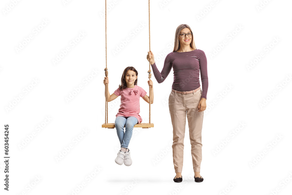 Full length portrait of a woman standing next to girl on a wooden swing Full length portrait of a woman standing next to girl on a wooden swing