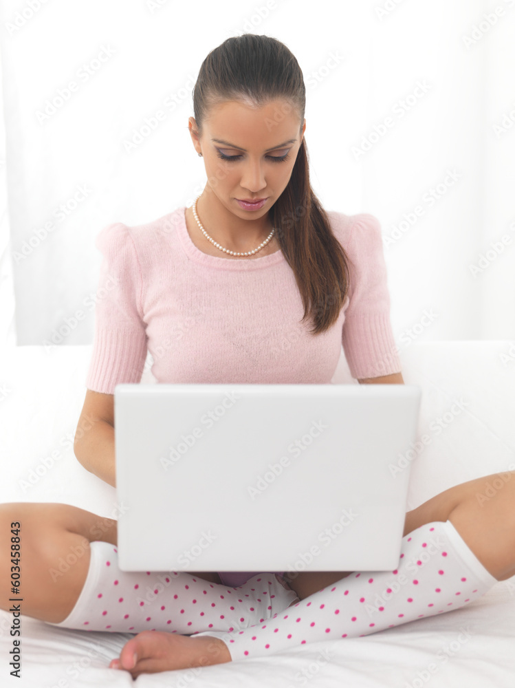 Young pretty women on white couch relaxing and using laptop computer Young pretty women on white couch relaxing and using laptop computer
