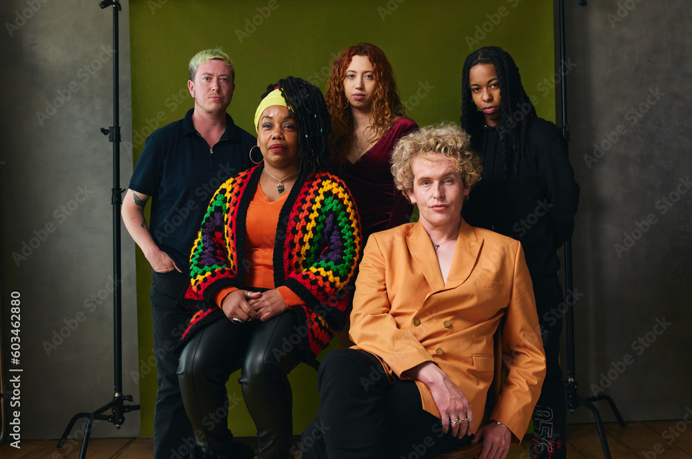Portrait of five LGBTQIA queer people against studio backdrop for pride month