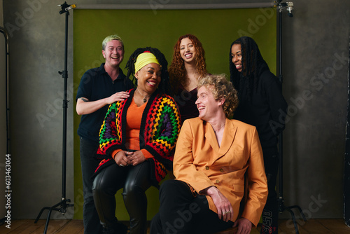 Portrait of five LGBTQIA queer people laughing against studio backdrop gay pride