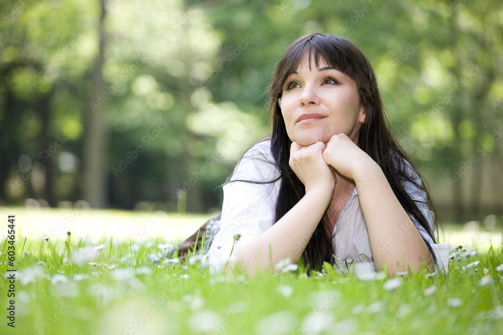 attractive brunette woman relaxing on grass attractive brunette woman relaxing on grass