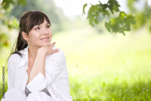 attractive brunette woman relaxing on grass