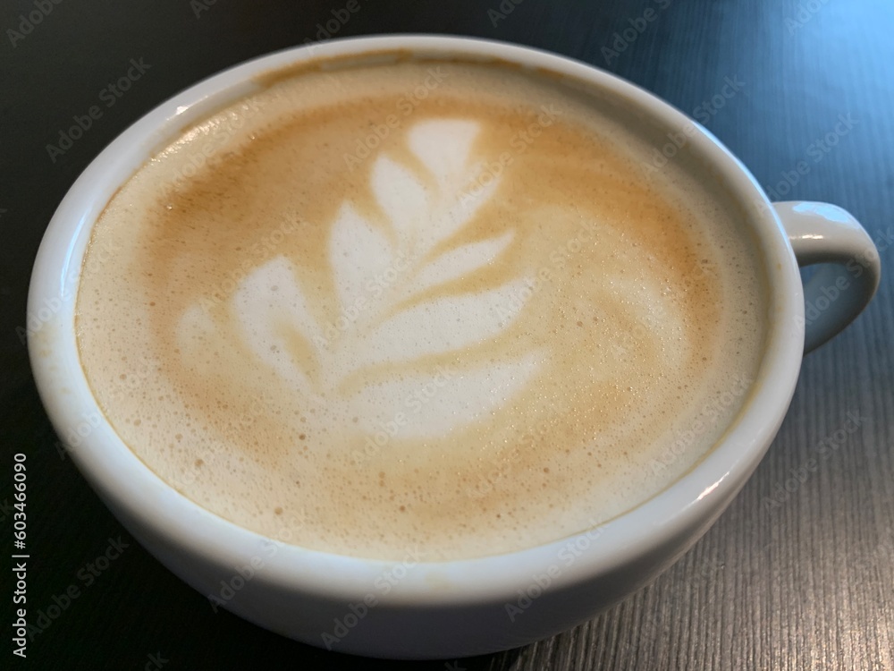 Cappuccino coffee in a beautiful glass on the table. Concept: favorite cup of coffee with milk. Latte in a coffee cup, nicely decorated. Cappuccino coffee in a beautiful glass on the table. Concept: favorite cup of coffee with milk. Latte in a coffee cup, nicely decorated.