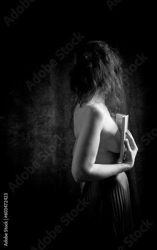 woman in black skirt reading a book in romantic attitude III