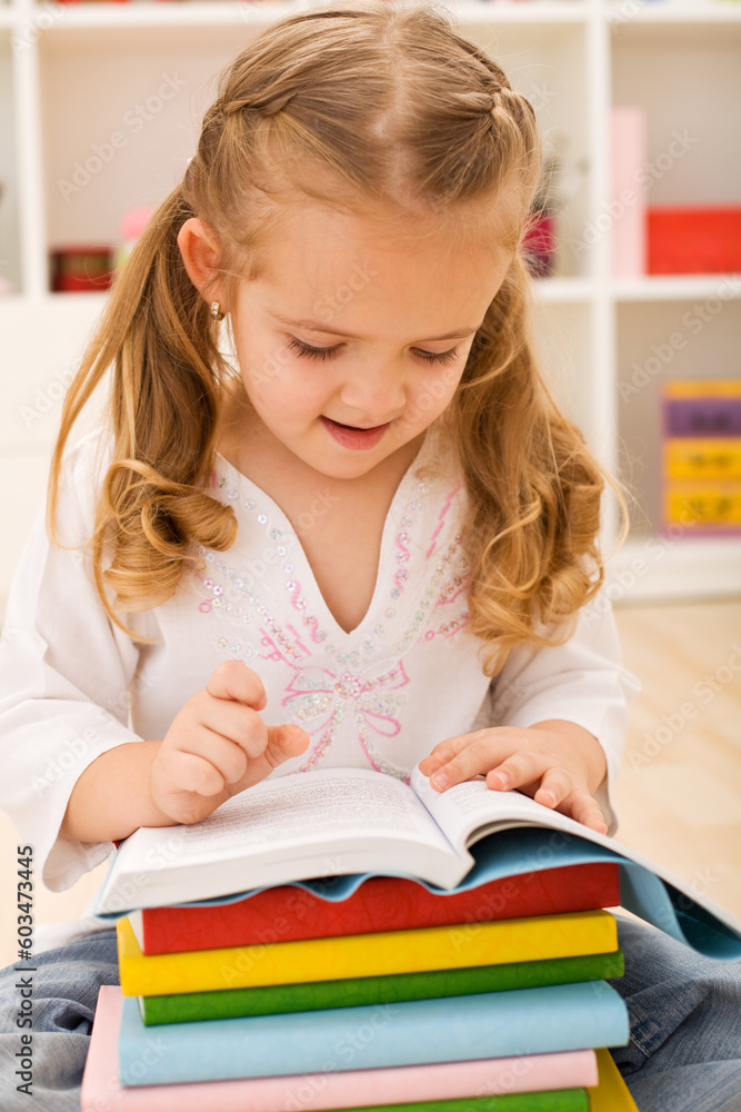 Little girl preparing for school - sitting with a stack of books in her lap Little girl preparing for school - sitting with a stack of books in her lap