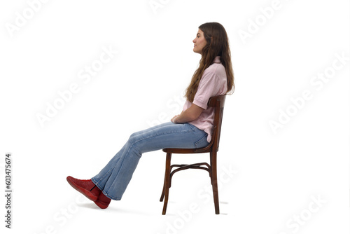 Side view of a young girl sitting on chair with Stretched legs on white background