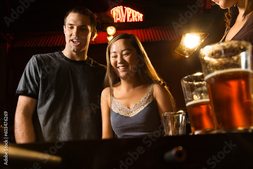 Young couple teamed up at foosball game in pub.