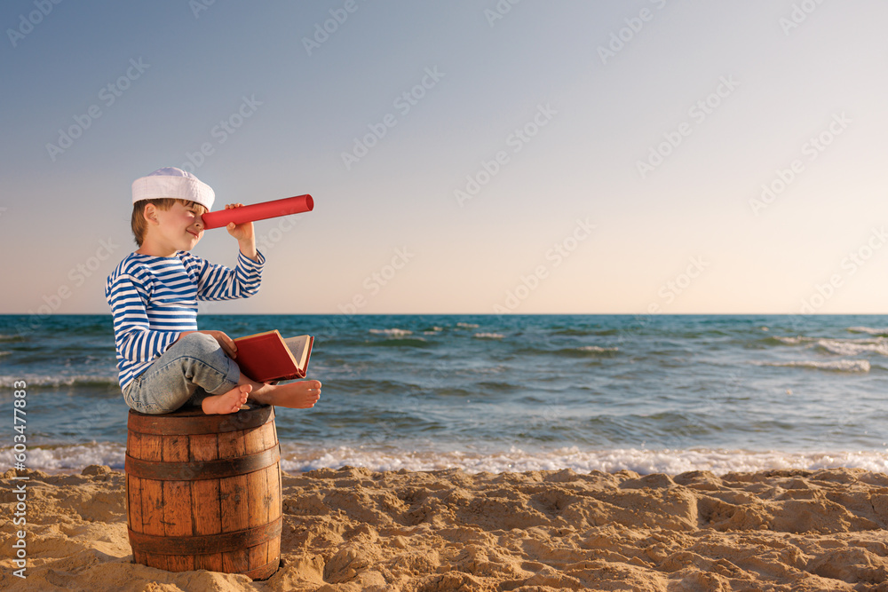 Obraz Happy child sitting on old barrel against sea and sky. Summer vacation and travel concept fototapeta, plakat
