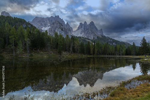 Lake Antorno in the Italian Dolomites with reflection of mountains in the water. There are beautiful clouds in the sky. You can see the road to Tre Cime.