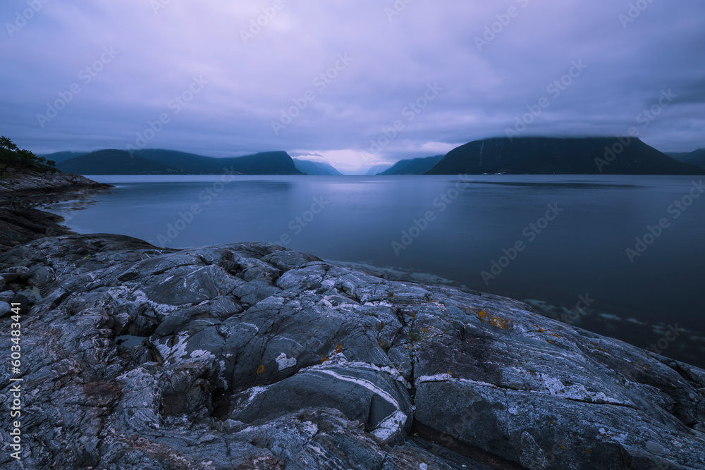 Fototapeta premium Evening view of the fjords and mountains around Solavågen in Norway. Rocks are in the forground. Copy space, night, dusk, twilight, nordic, north, beautiful, wonderful, mystic