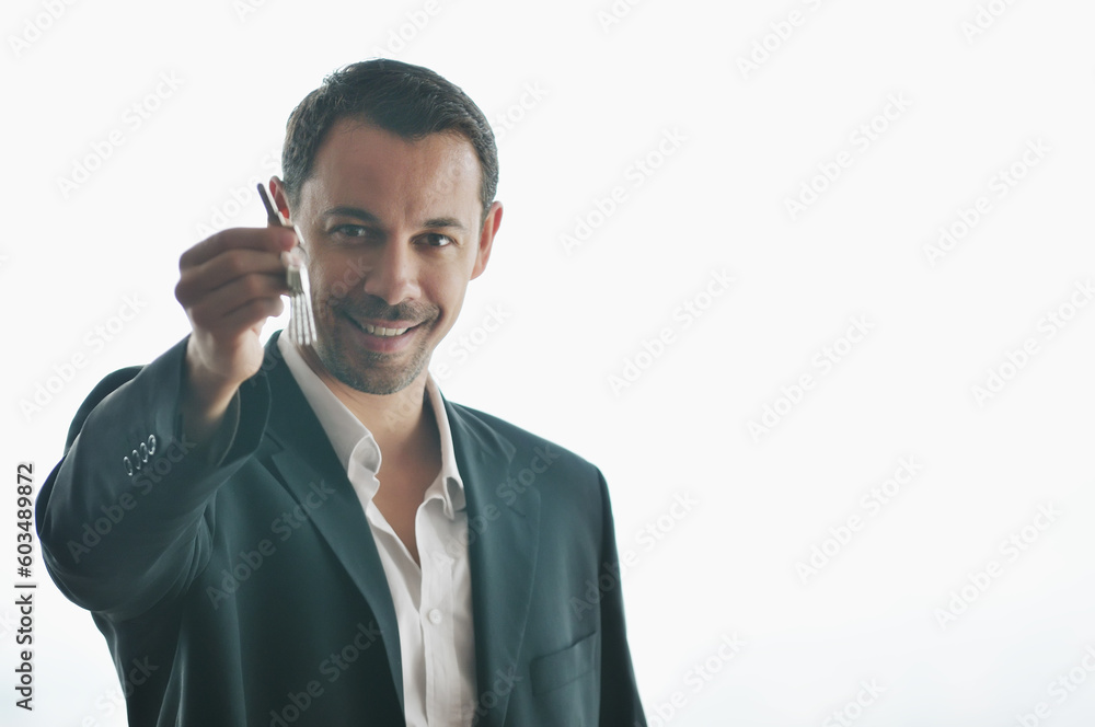 young business man isolated on white holding new home keys and representing sucess in real estate industry young business man isolated on white holding new home keys and representing sucess in real estate industry