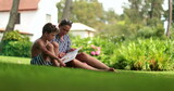 Casual mother and child boy reading outdoors